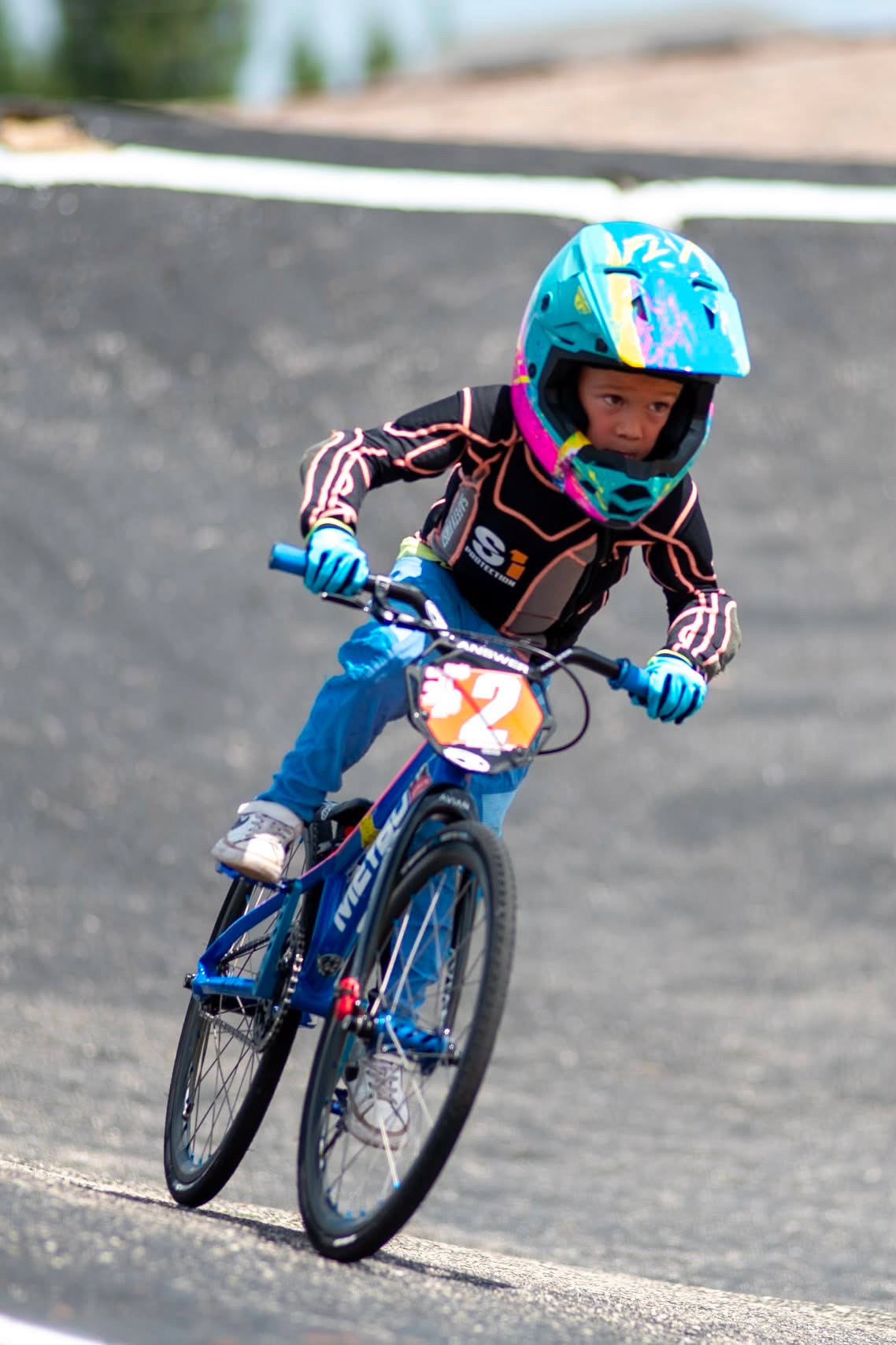 Sullivan Cagle leaning into a turn on his blue BMX bike