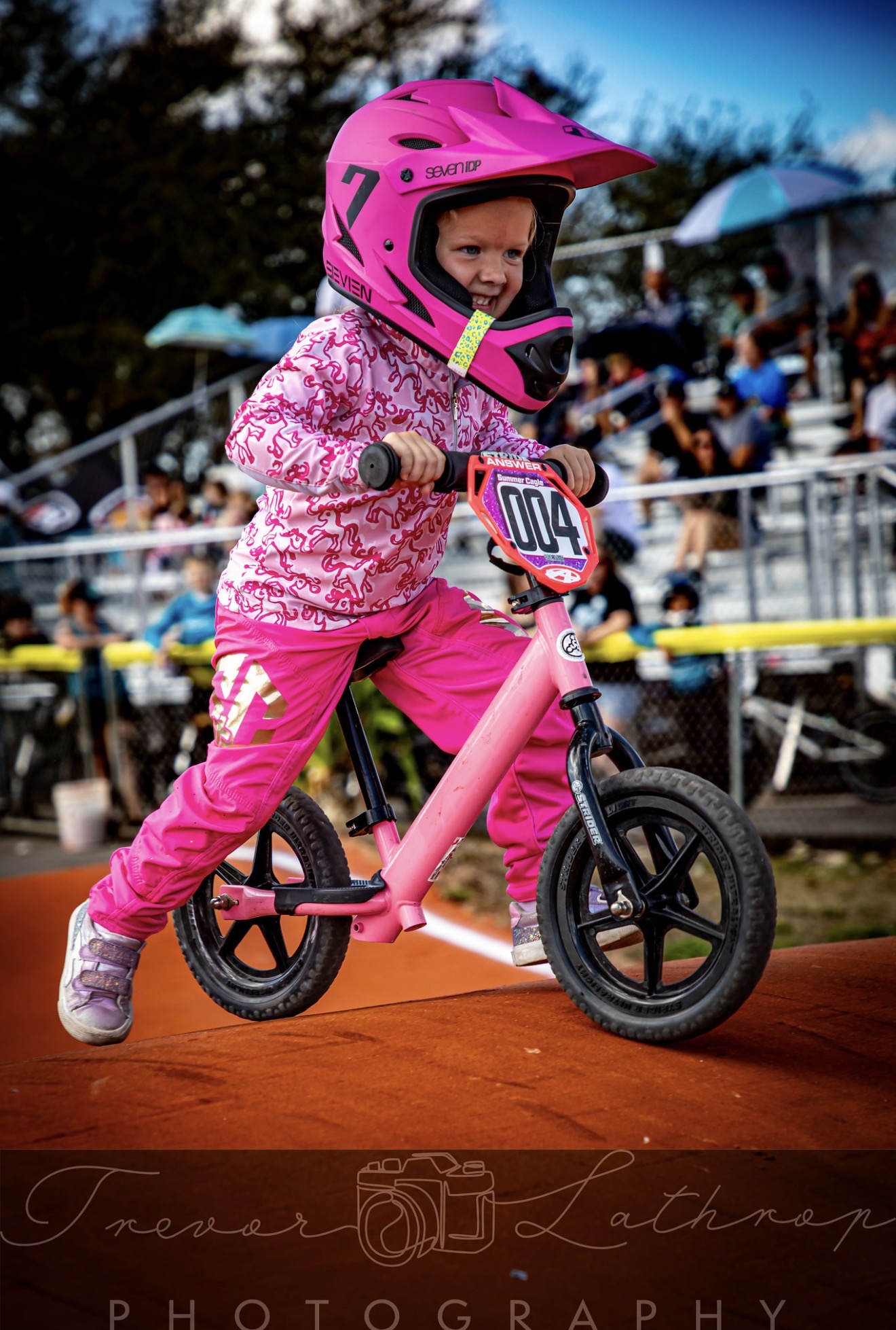 Summer Cagle smiling as she races her pink balance bike