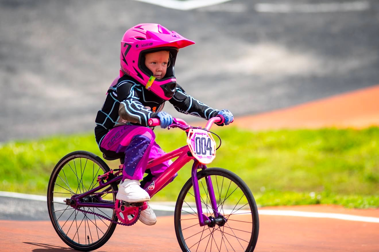 Summer Cagle racing her pink number 004 pedal BMX bike